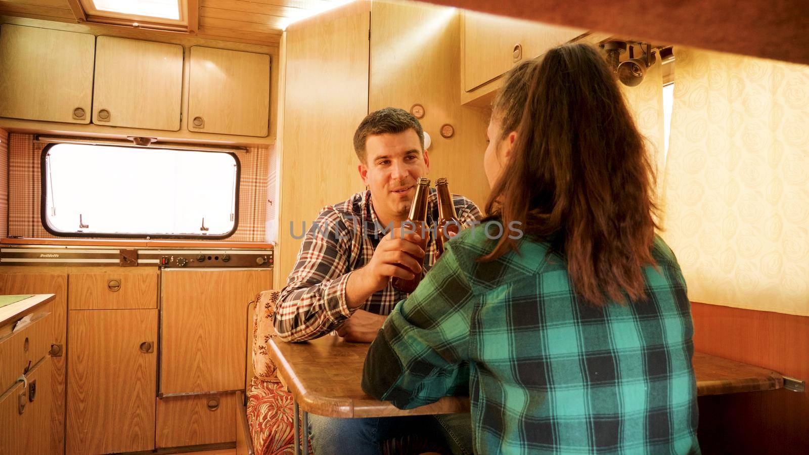 Passenger view of couple talking inside of their retro camper van. Autumn camping