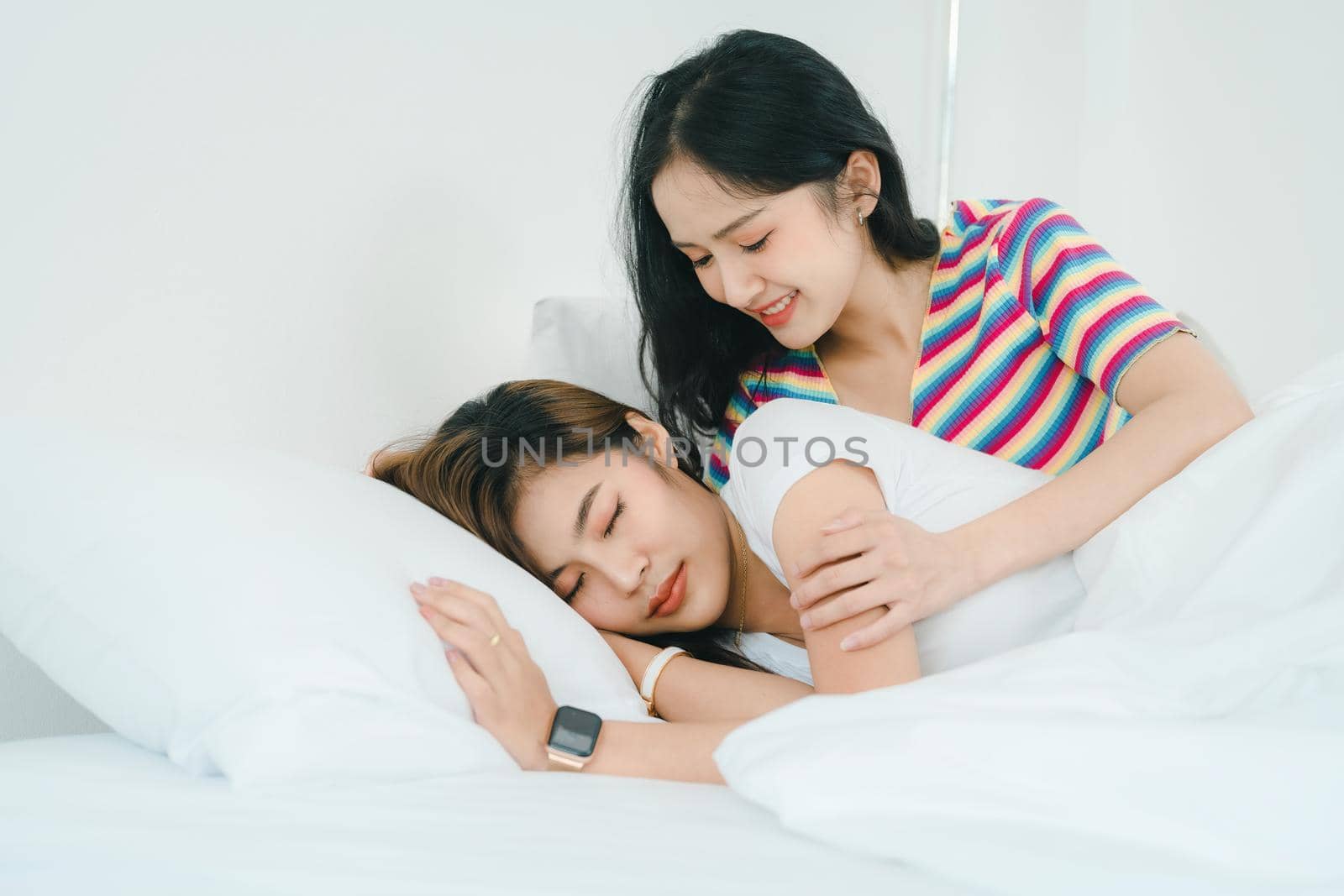 lgbtq, lgbt concept, homosexuality, portrait of two Asian women posing happy together and showing love for each other while being together at bedroom by Manastrong