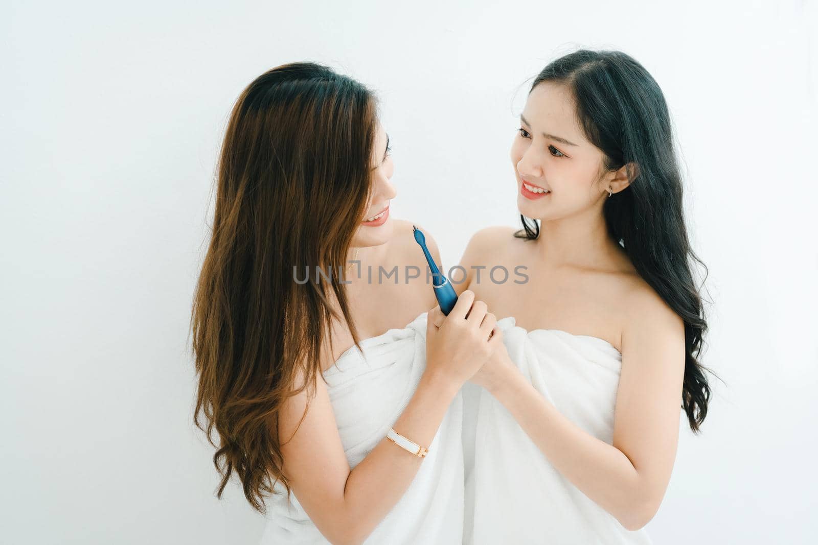 lgbtq, lgbt concept, homosexuality, portrait of two asian women posing happy together and showing love for each other while brushing teeth.