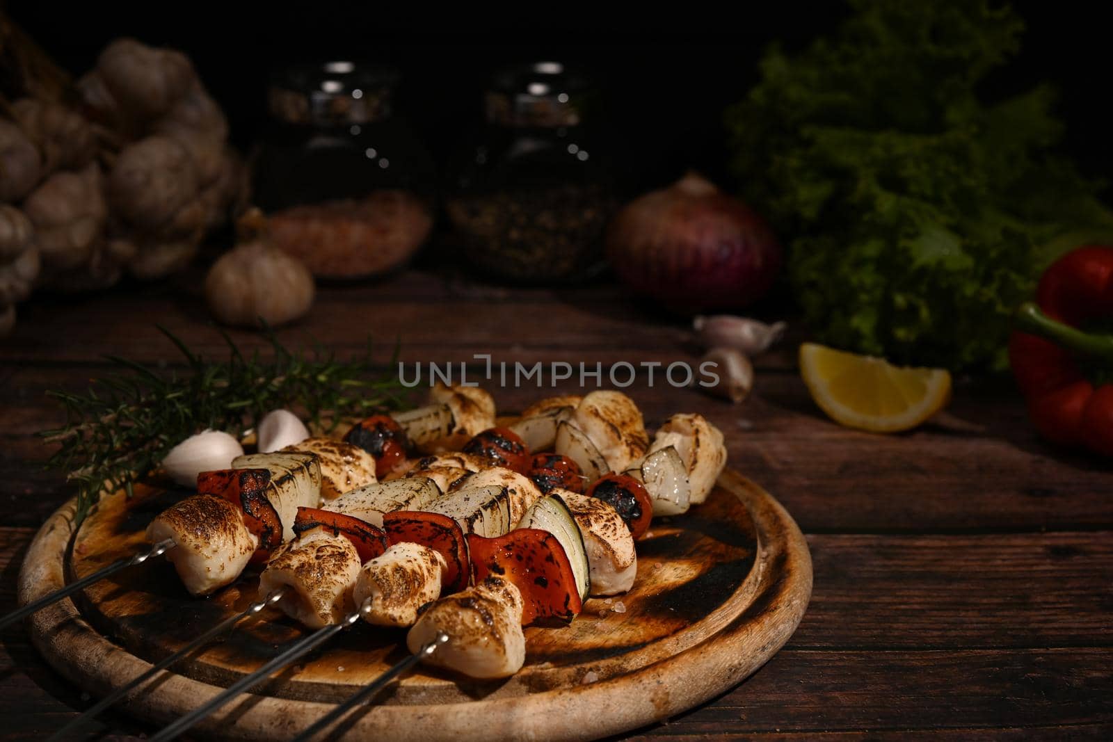 Close up tasty grilled chicken skewers with tomato, sweet pepper and onions on cutting board ready to serve.