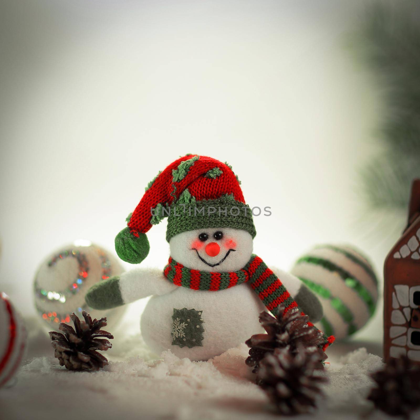 toy snowman and a gingerbread house on a light background. photo with copy space.