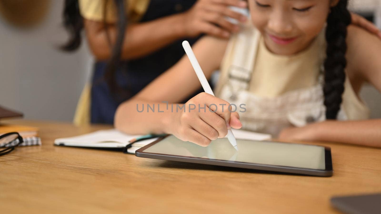 Focused asian girl using digital tablet, doing homework, studying online on web virtual class by prathanchorruangsak