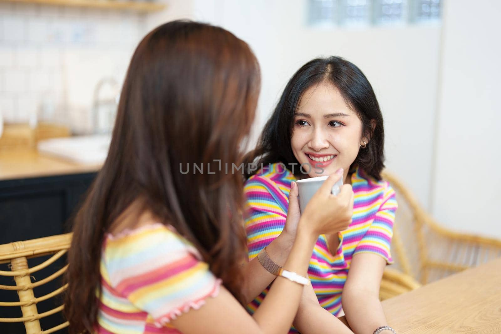 lgbtq, LGBT concept, homosexuality, portrait of two Asian women posing happy together and showing love for each other while having coffee at the dining table.