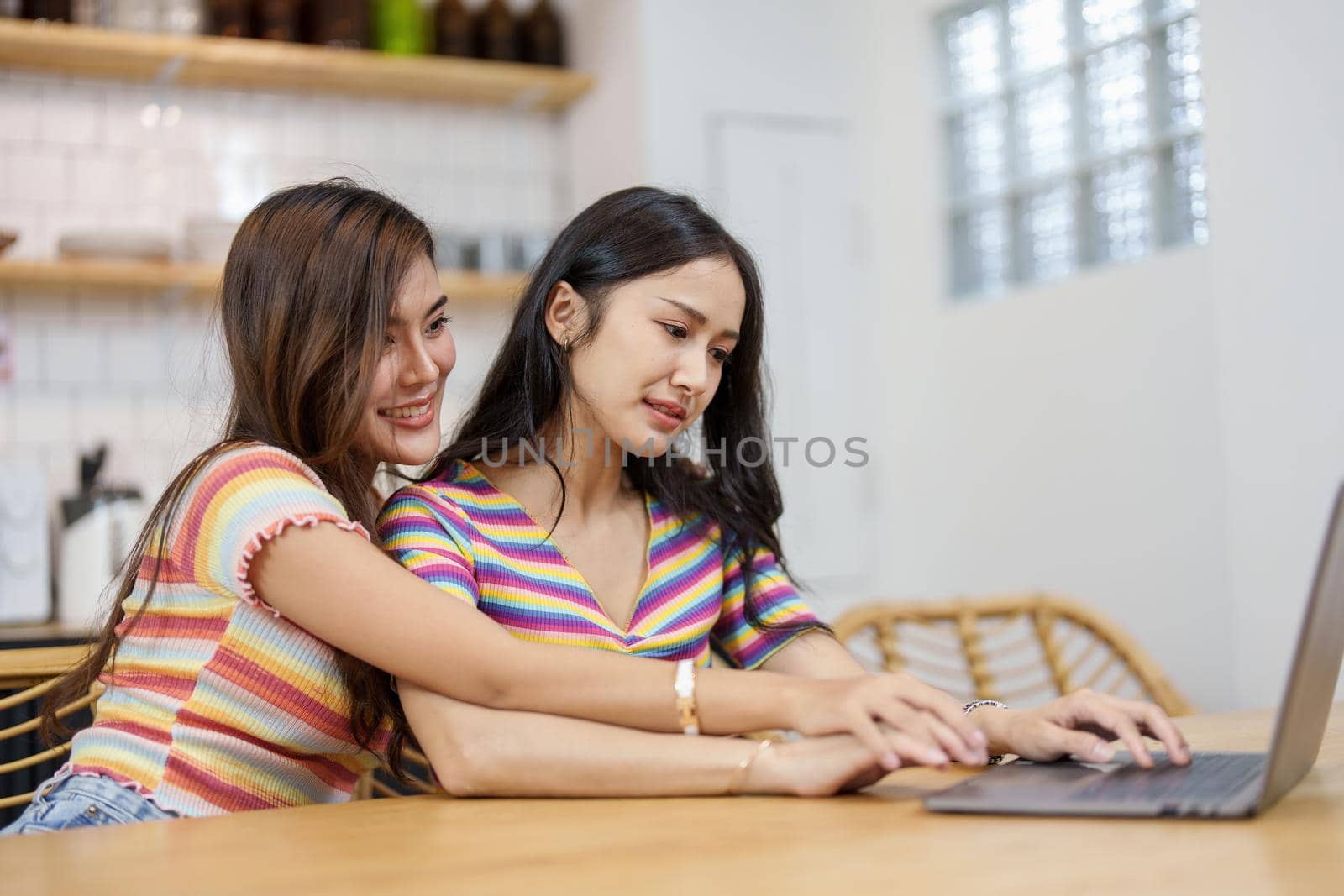 lgbtq, lgbt concept, homosexuality, portrait of two asian women posing happy together and loving each other while playing computer laptop on bed by Manastrong