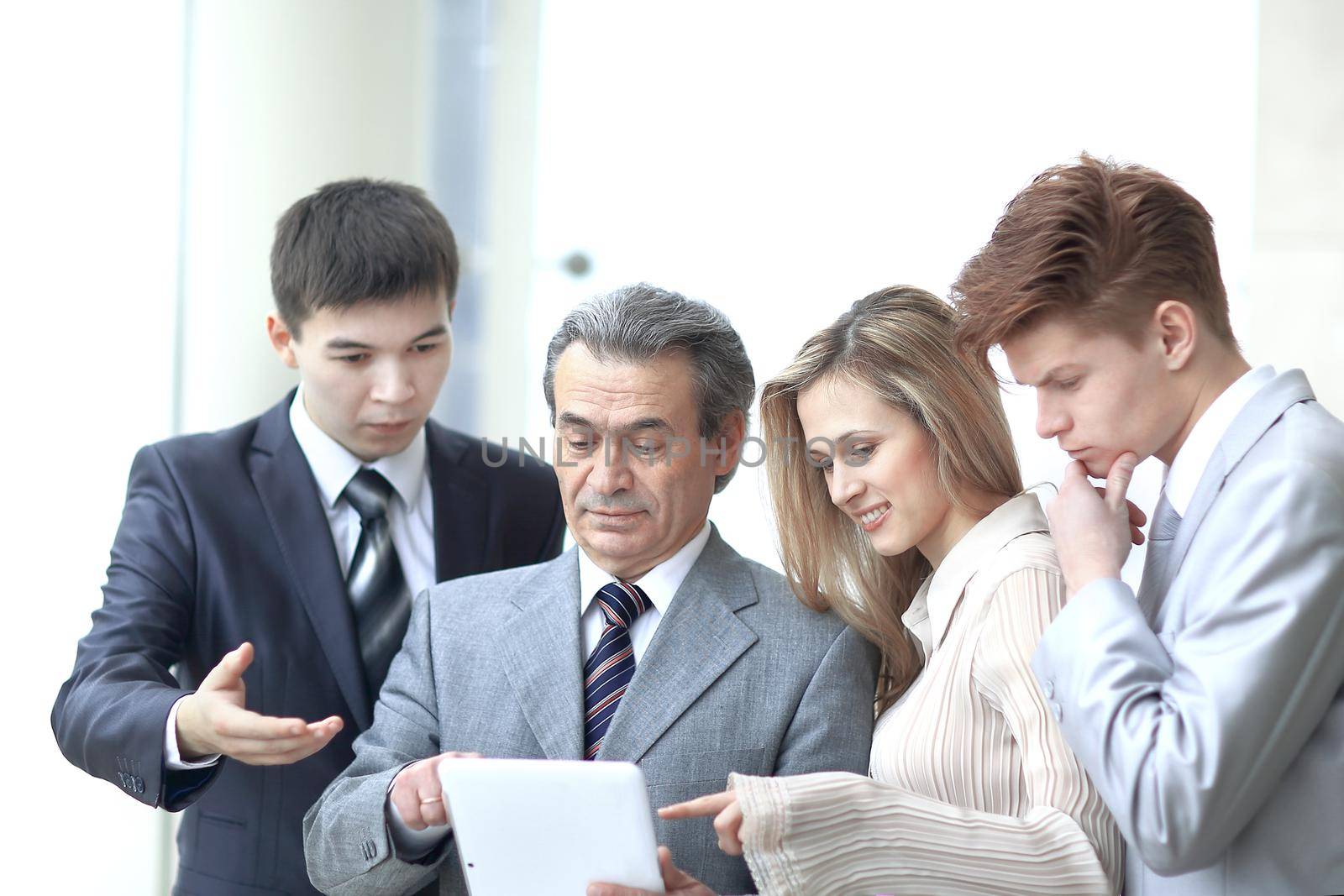 businessman and his team look at the screen of the digital tablet.