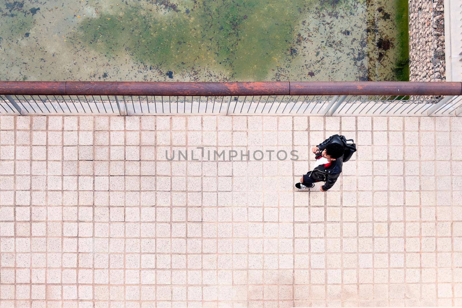 top view of a young urban man walking with a backpack, concept of urban lifestyle