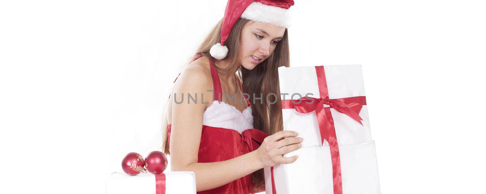 beautiful young woman in a Christmas costume looking at a box of Christmas gifts. photo with copy space.