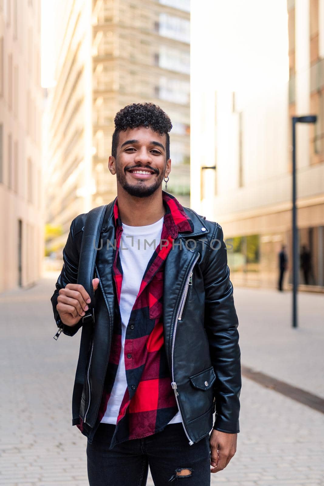 stylish young latin student smiling happy in the city, concept of urban lifestyle