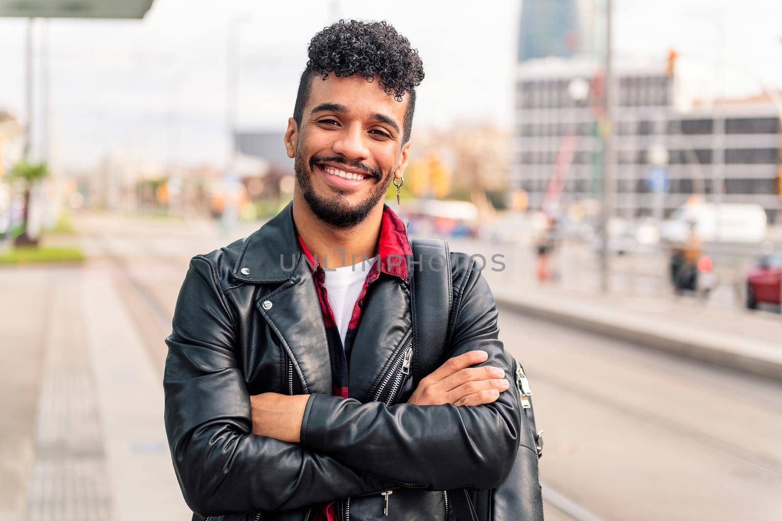 stylish young latin entrepreneur smiles happy looking at camera with his arms crossed, concept of urban lifestyle