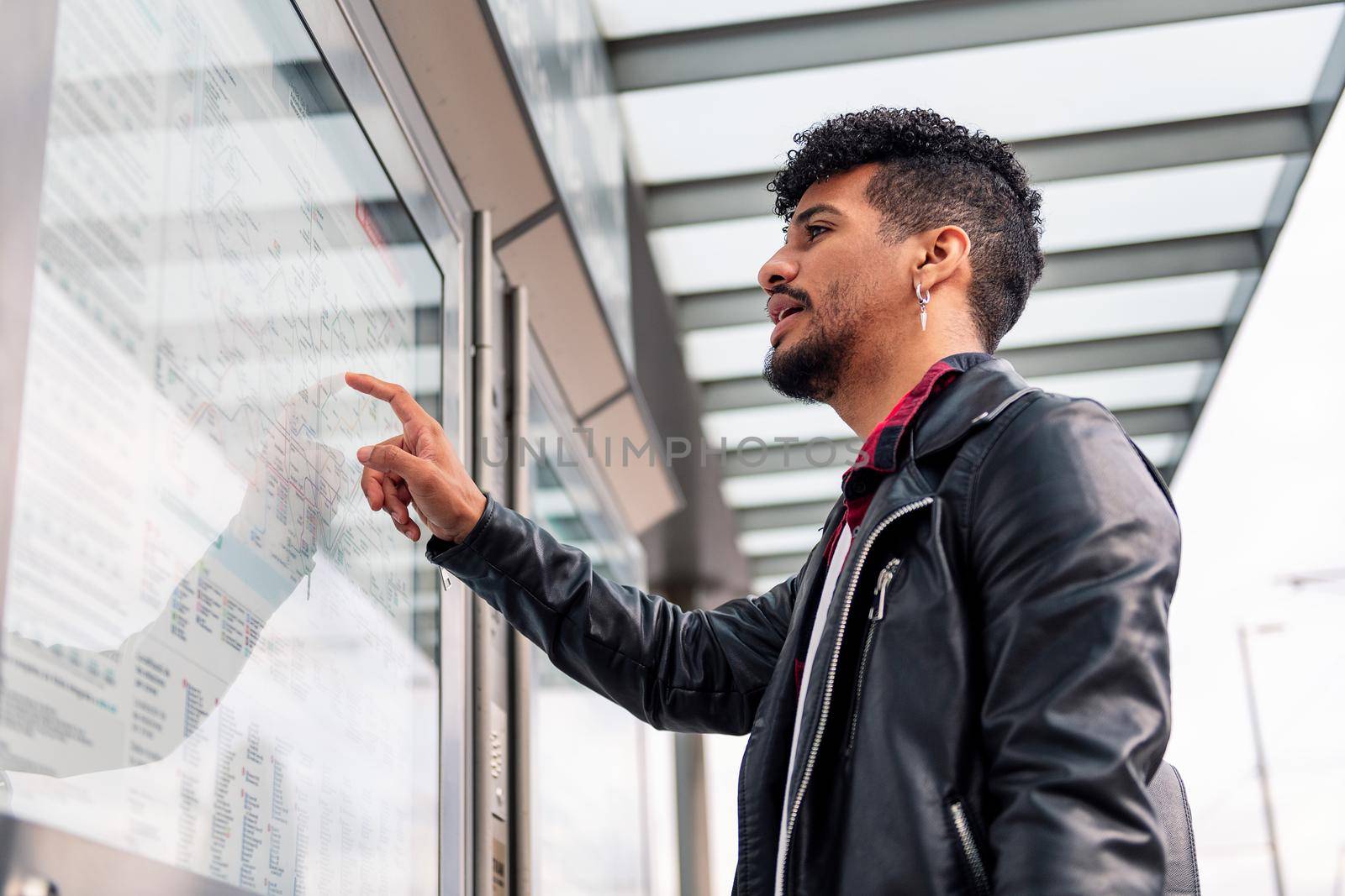 latin man consulting the public transportation map by raulmelldo