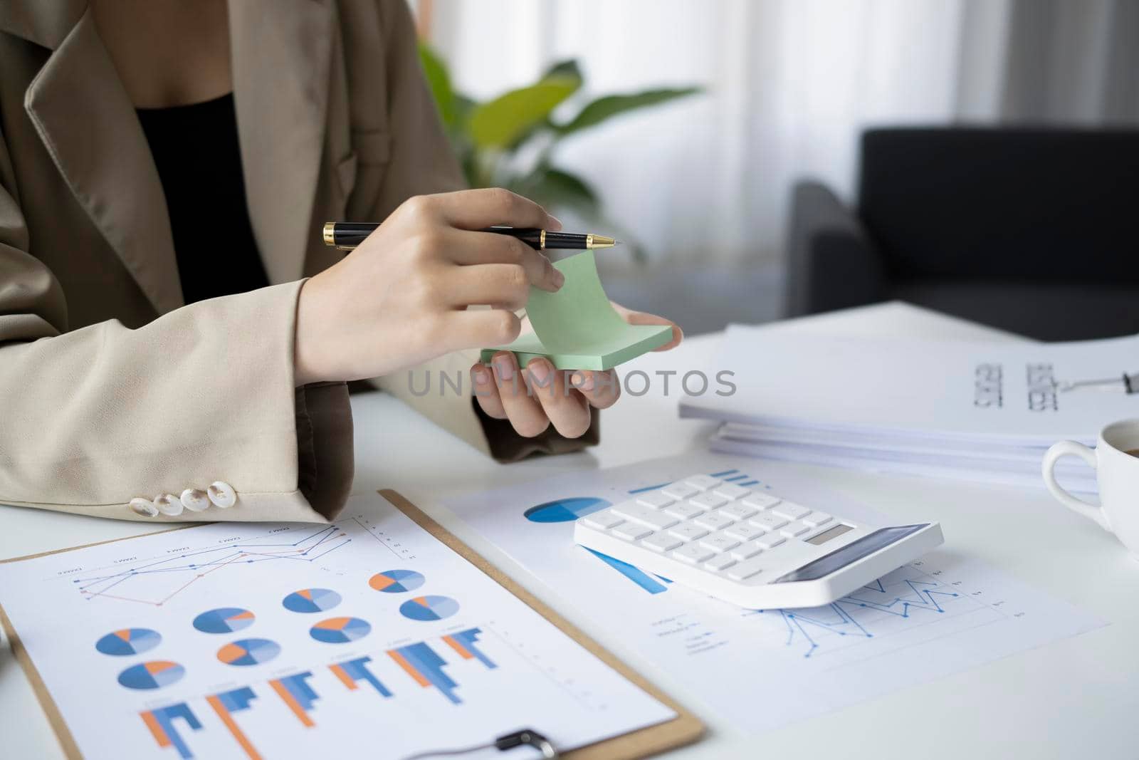 Female accountant writing her new idea on sticky notes.