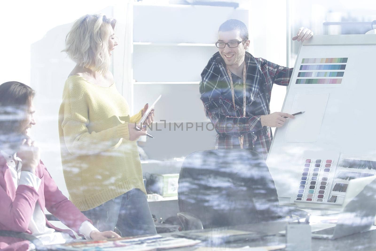 view through the glass wall. a group of fashion designers discussing new ideas by SmartPhotoLab