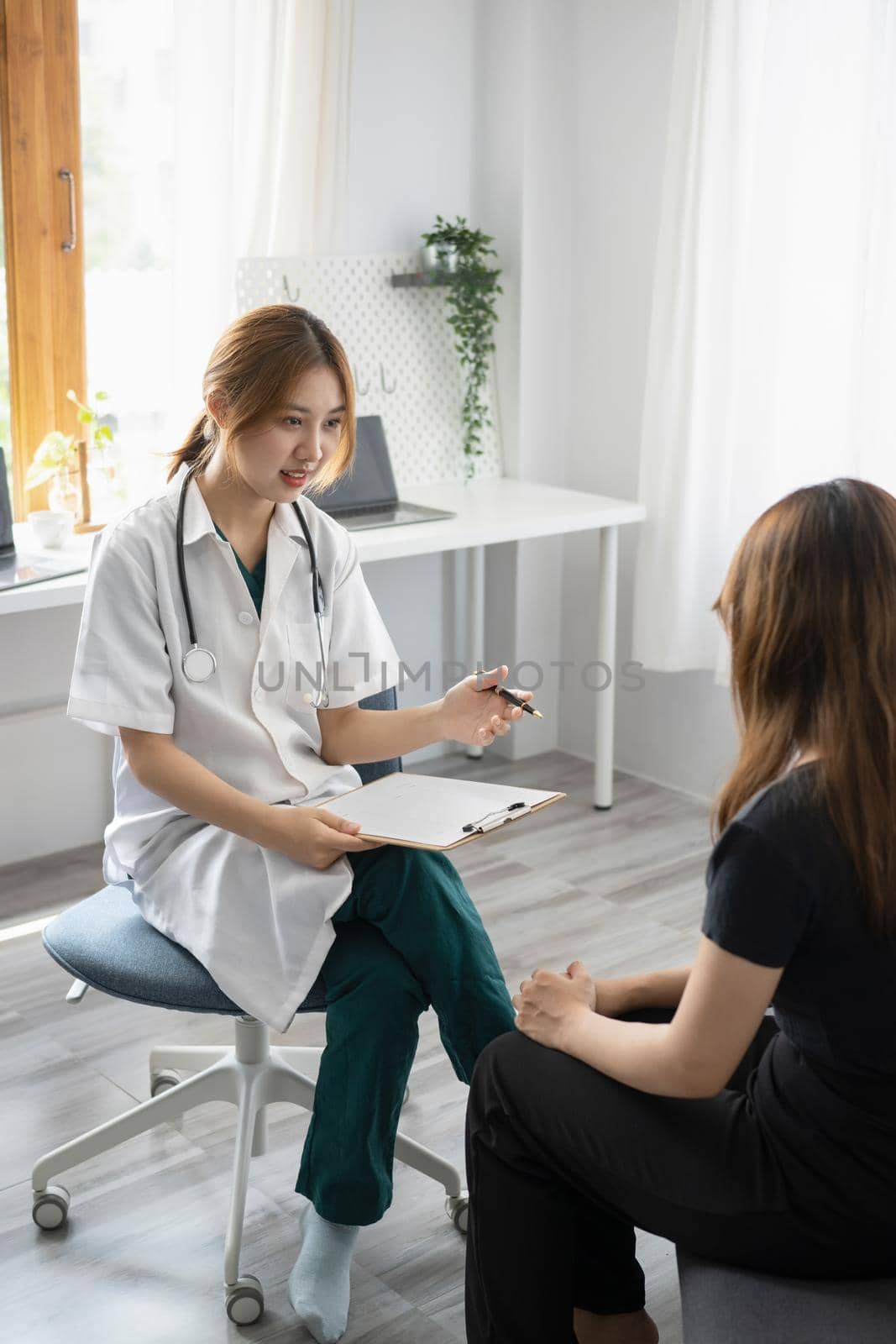 Female doctor in white medical coat giving consultation with patient in clinic or hospital. by prathanchorruangsak