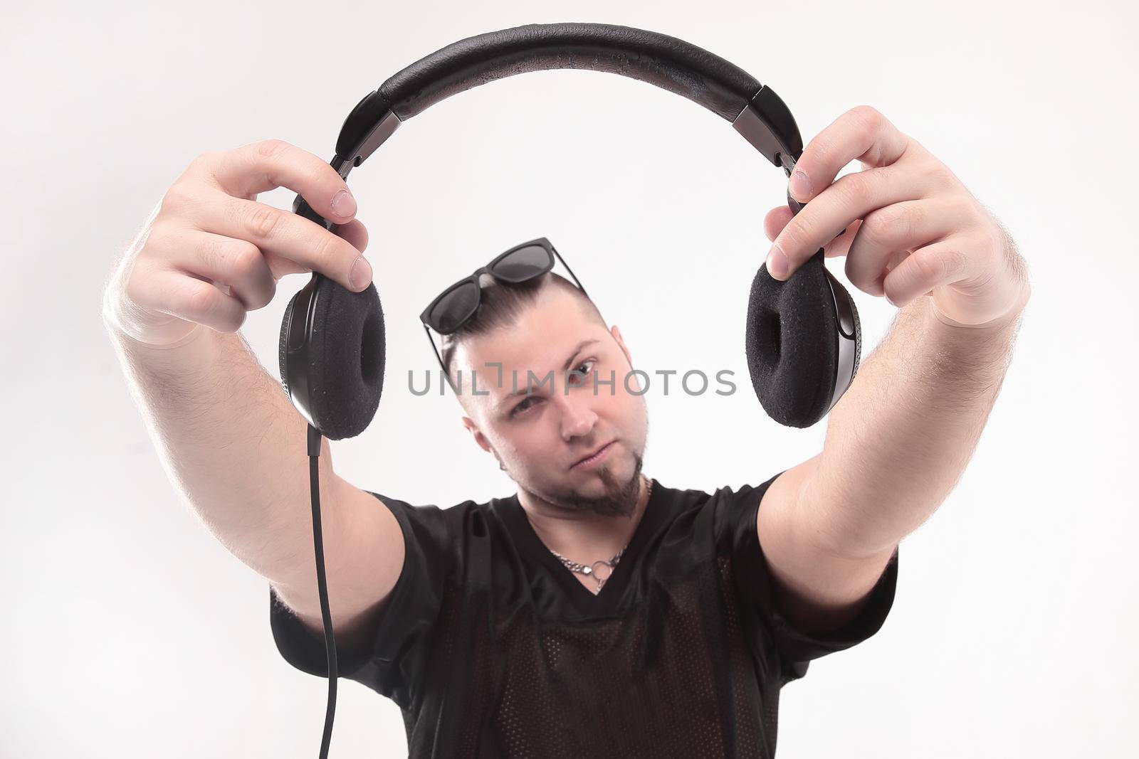 close up. stylish rapper shows headphones .isolated on white background.photo with copy space