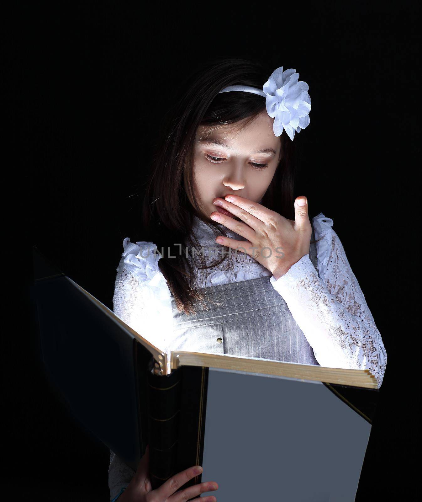 little girl reads an interesting tale .isolated on black background.