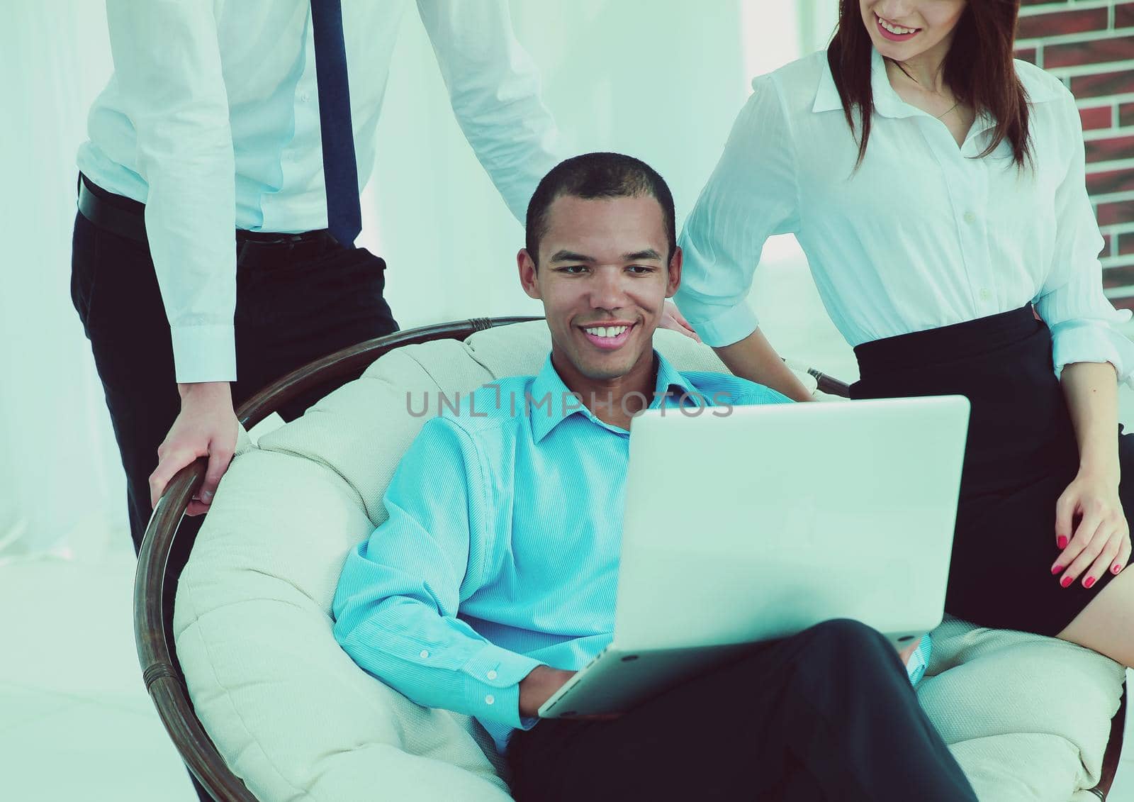 successful businessman with his assistants in a discussion of the information from the laptop.office life