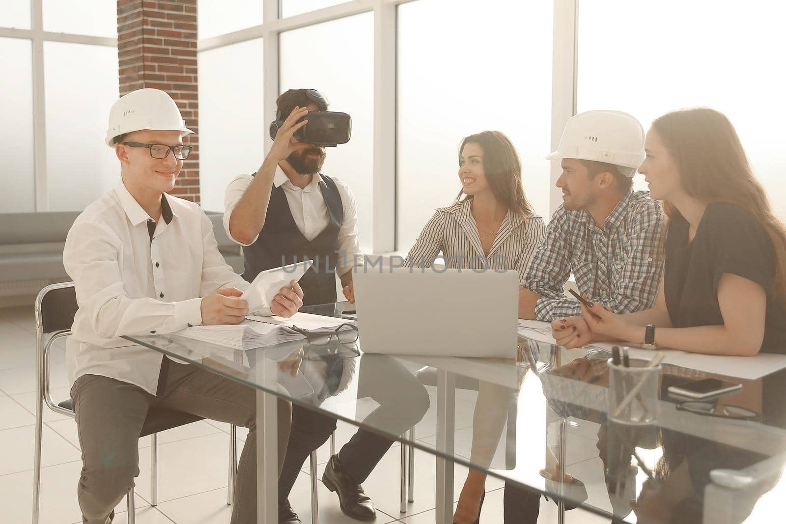 professional designers discussing ideas about blueprint during meeting table in modern studio
