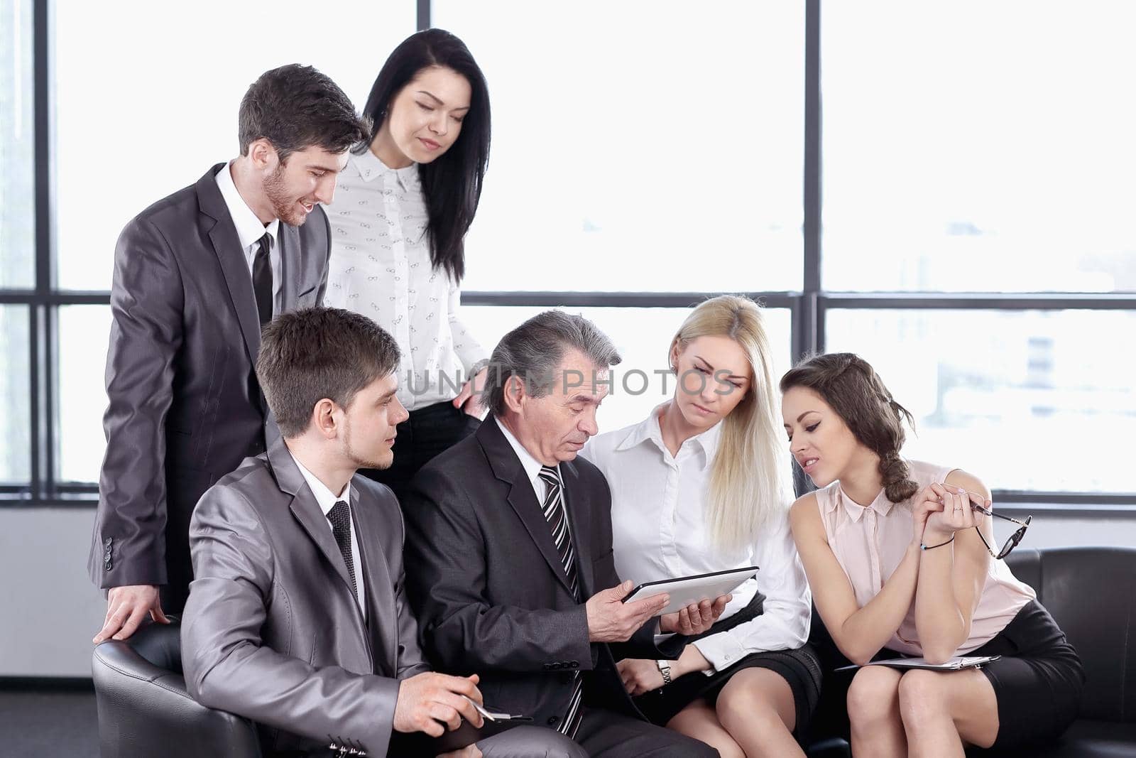 businessman uses a digital tablet at a working meeting with employees . business and technology