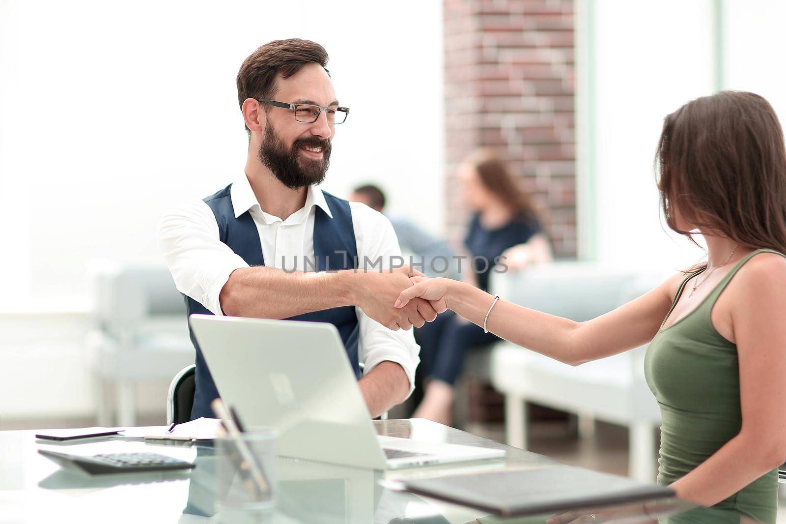 handshake of a Manager and a customer at the Desk.concept of partnership