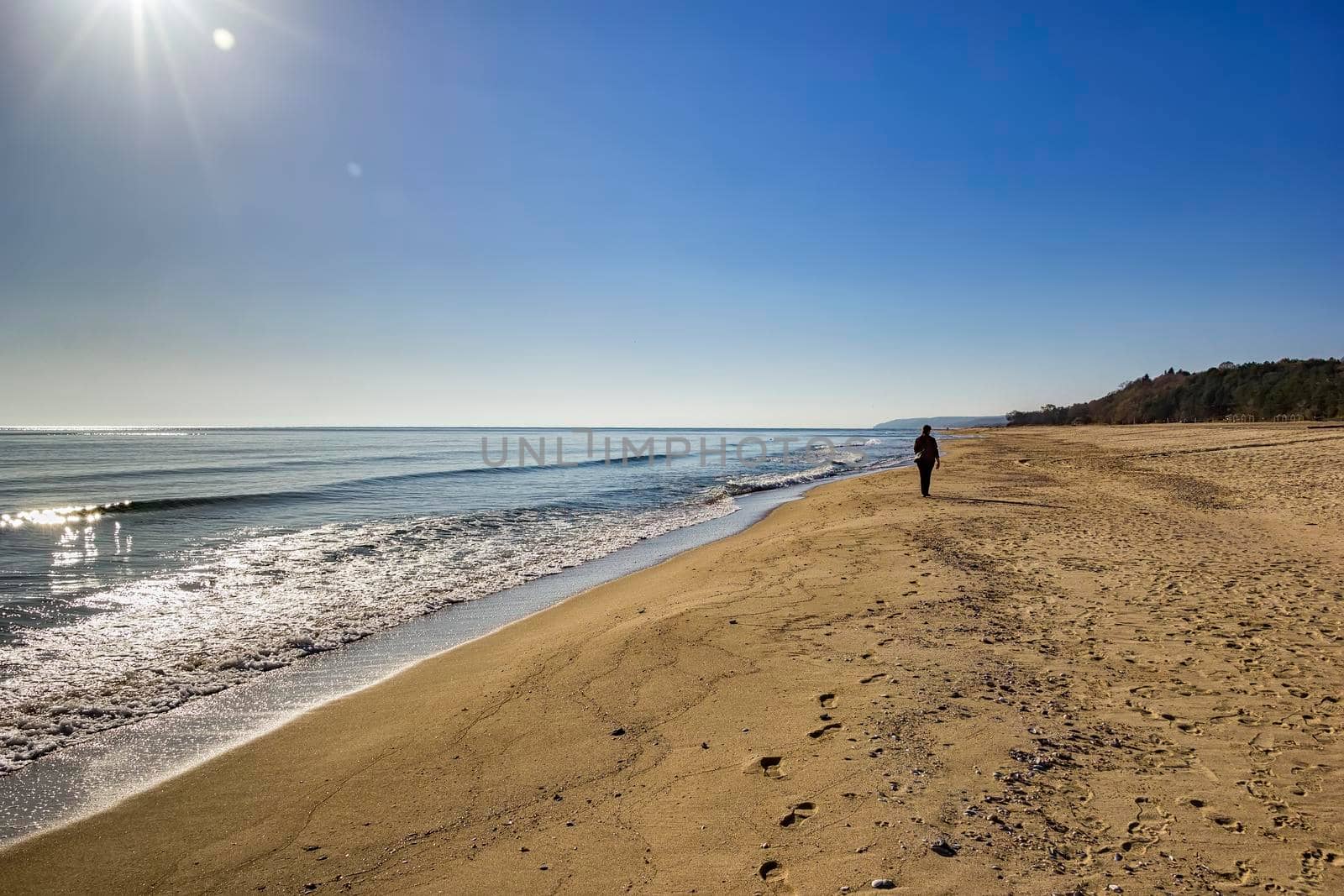 woman in summer walking in the sand by the sea beach