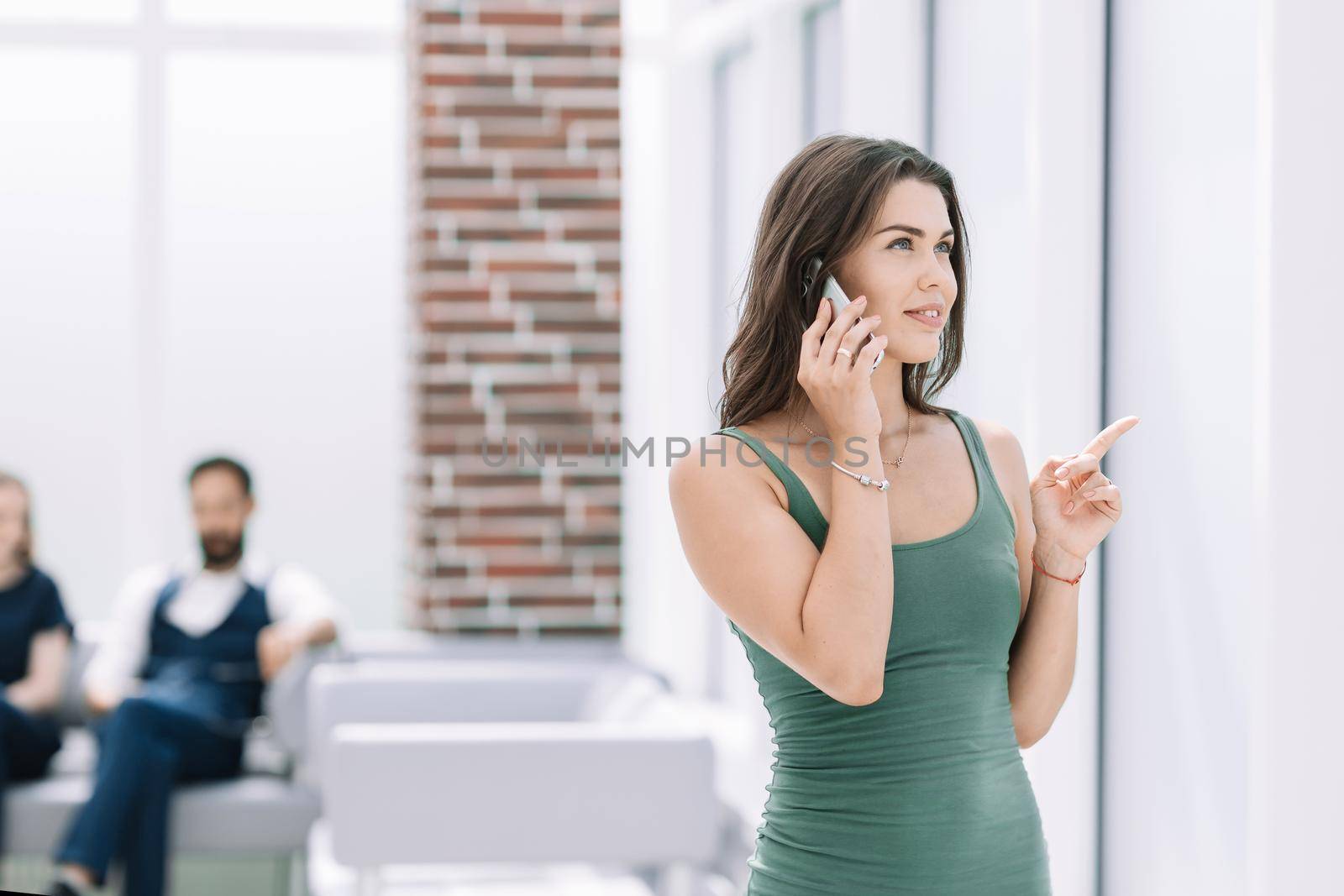 young woman talking on a smartphone standing in the office.photo with copy space