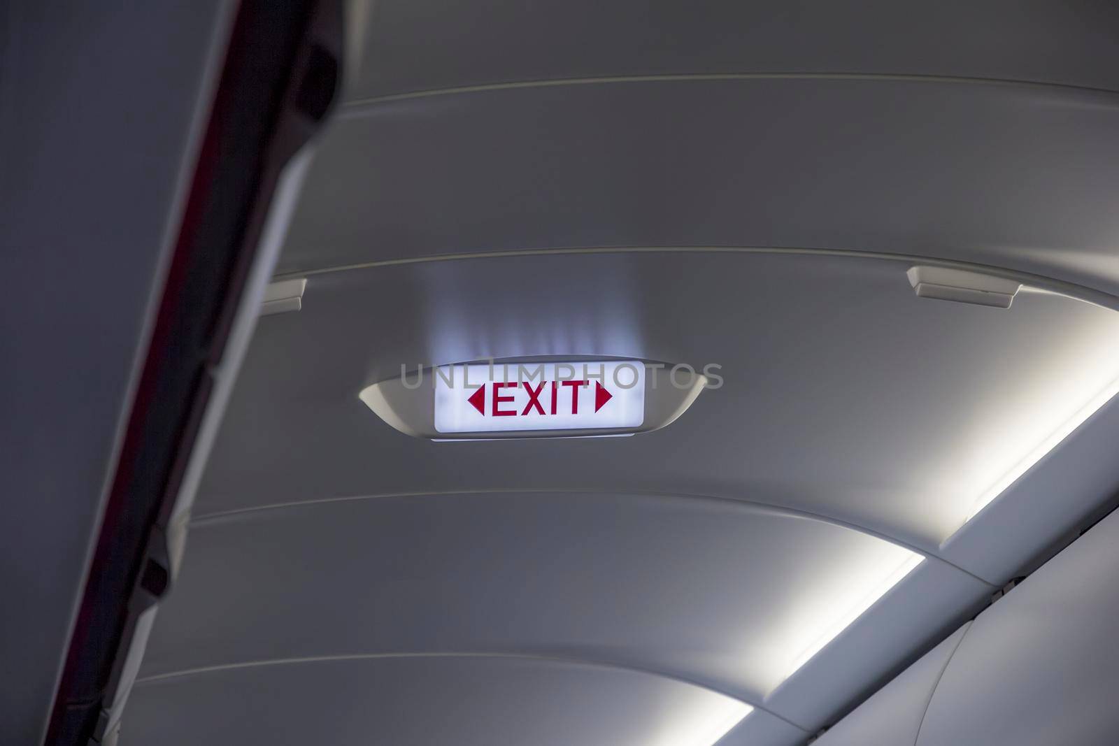 emergency exit sign on the ceiling of airplane 