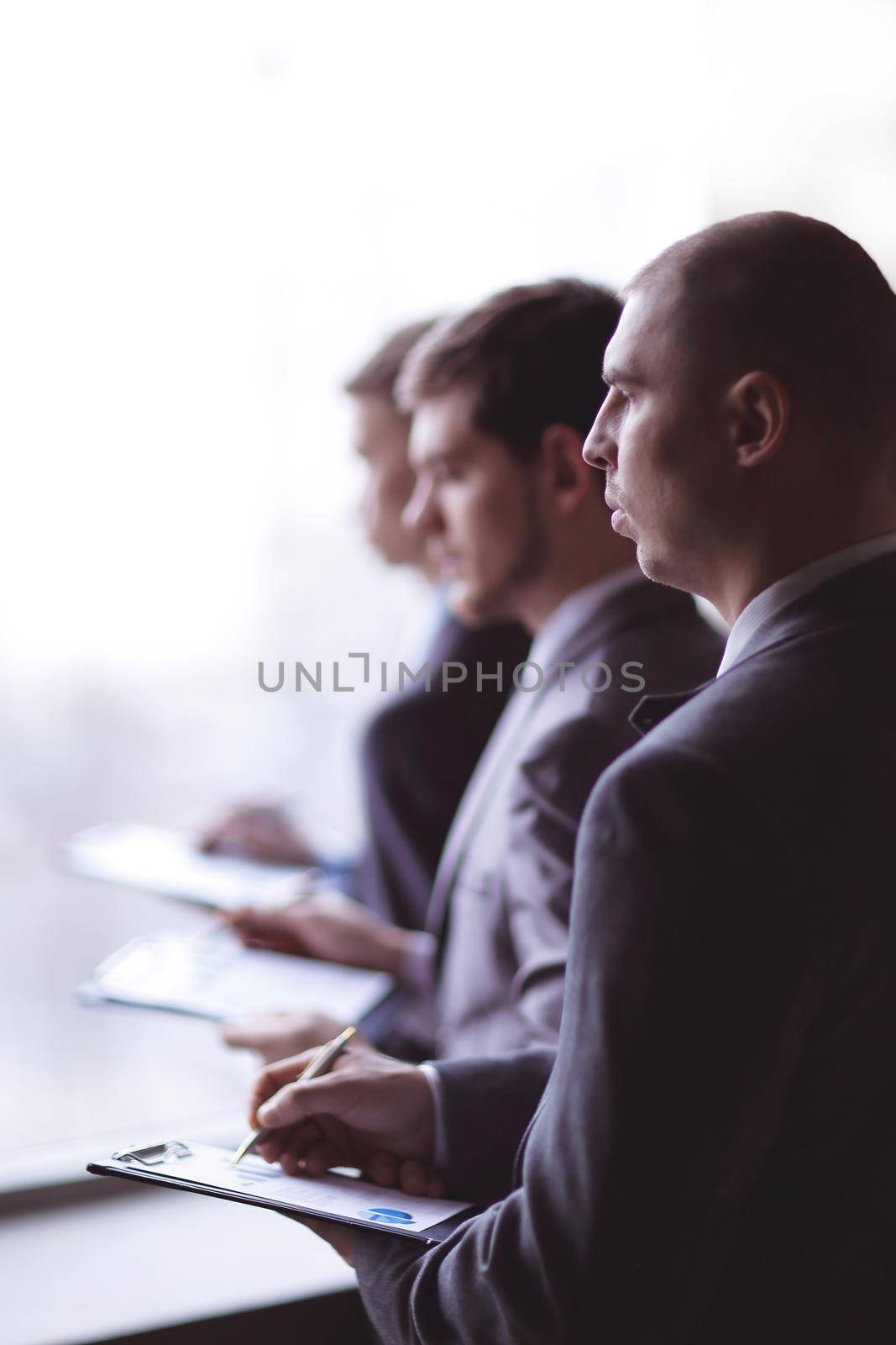 image of a businessman being at the conference and making notes on the foreground.