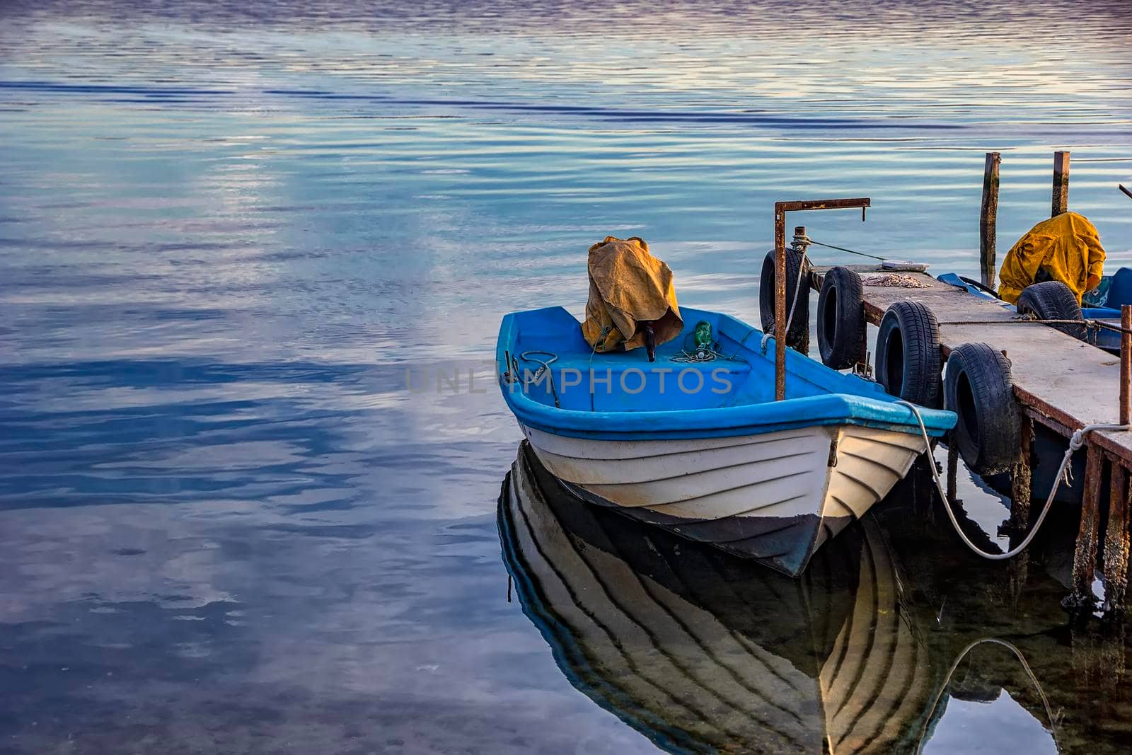Boat with water reflection in the summer evening at a pier 