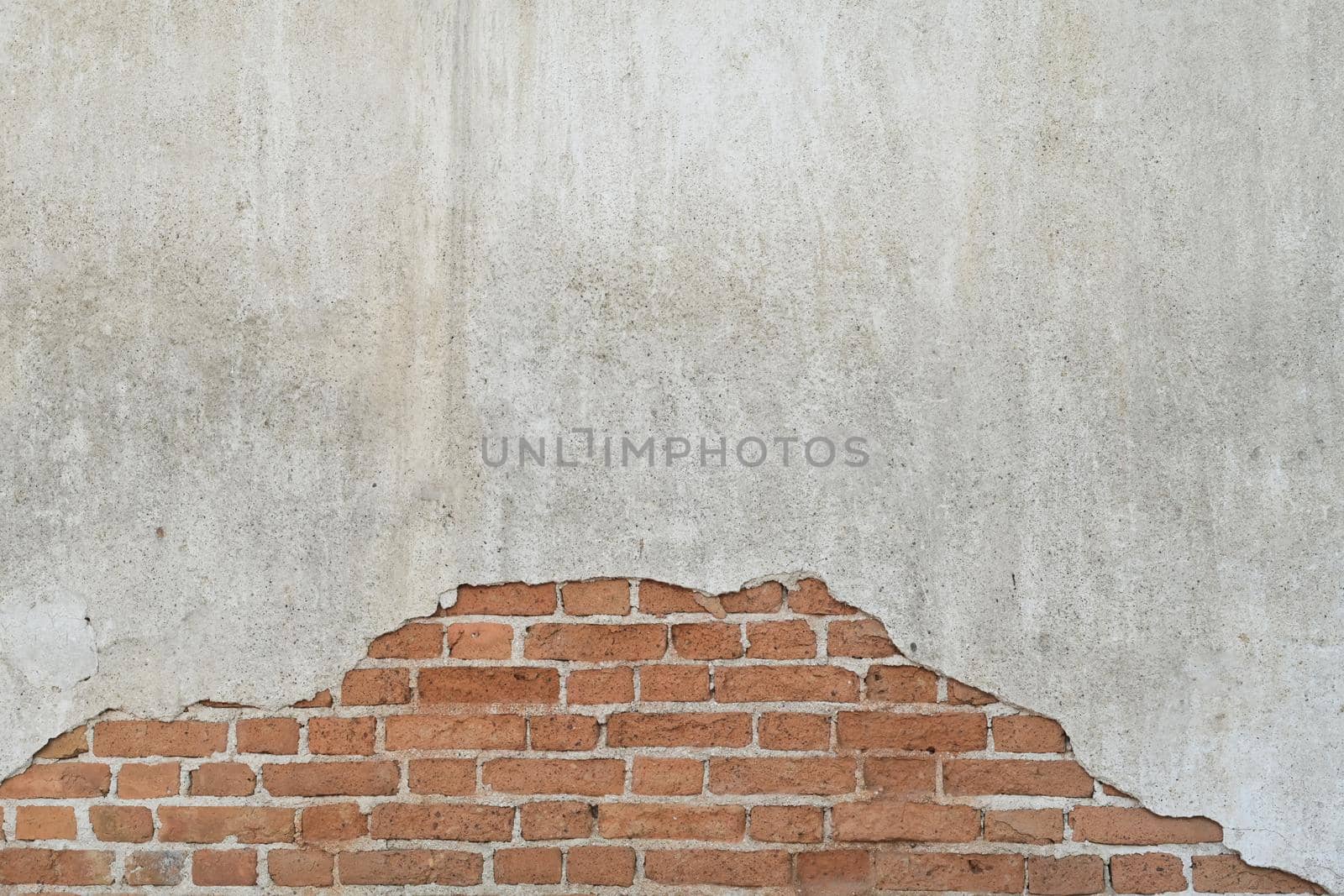 Old brick wall with peeling plaster, grunge background. Copy space for your text. by prathanchorruangsak