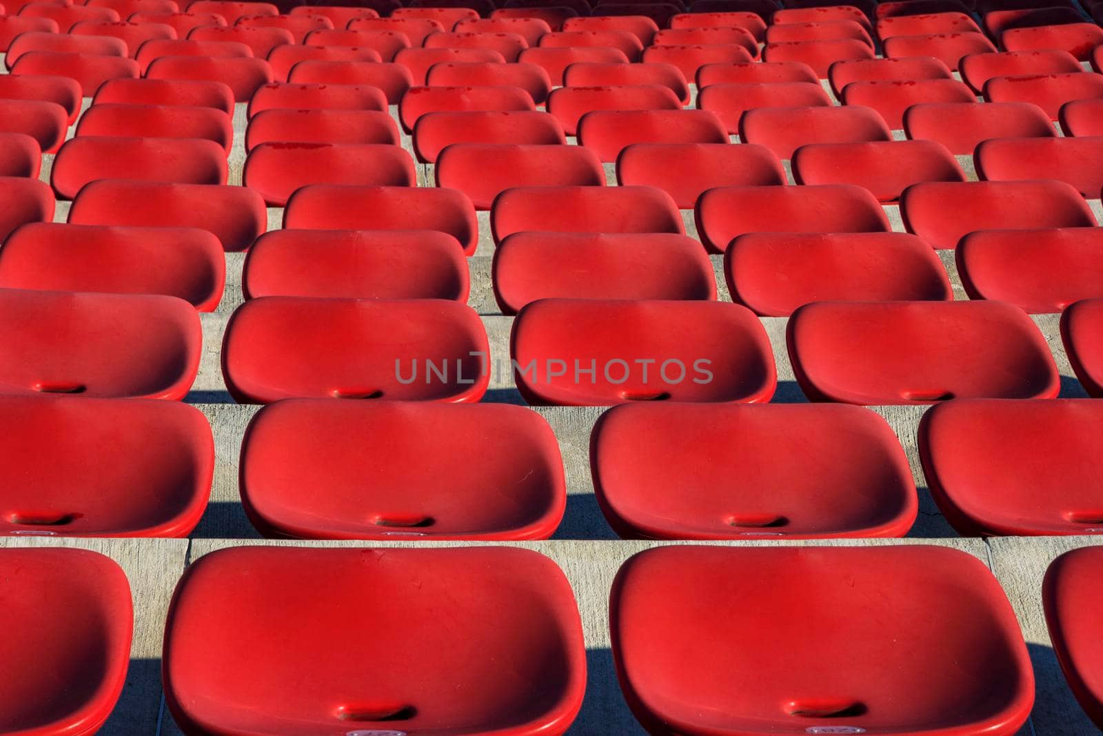 Empty plastic red chairs In outdoor theater  in sunny day. Close Up.