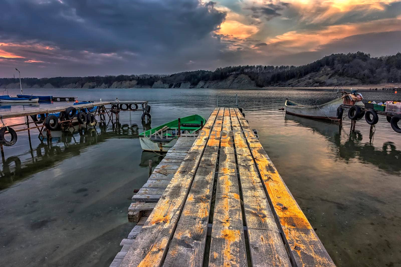 exciting landscape of wooden pier and boats at sunset