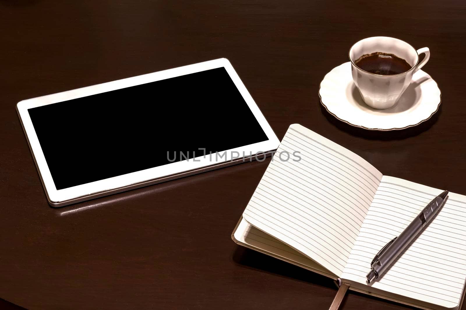 Work table: tablet PC, glasses, notebook, pencil and coffee. Gadgets on a wooden table.