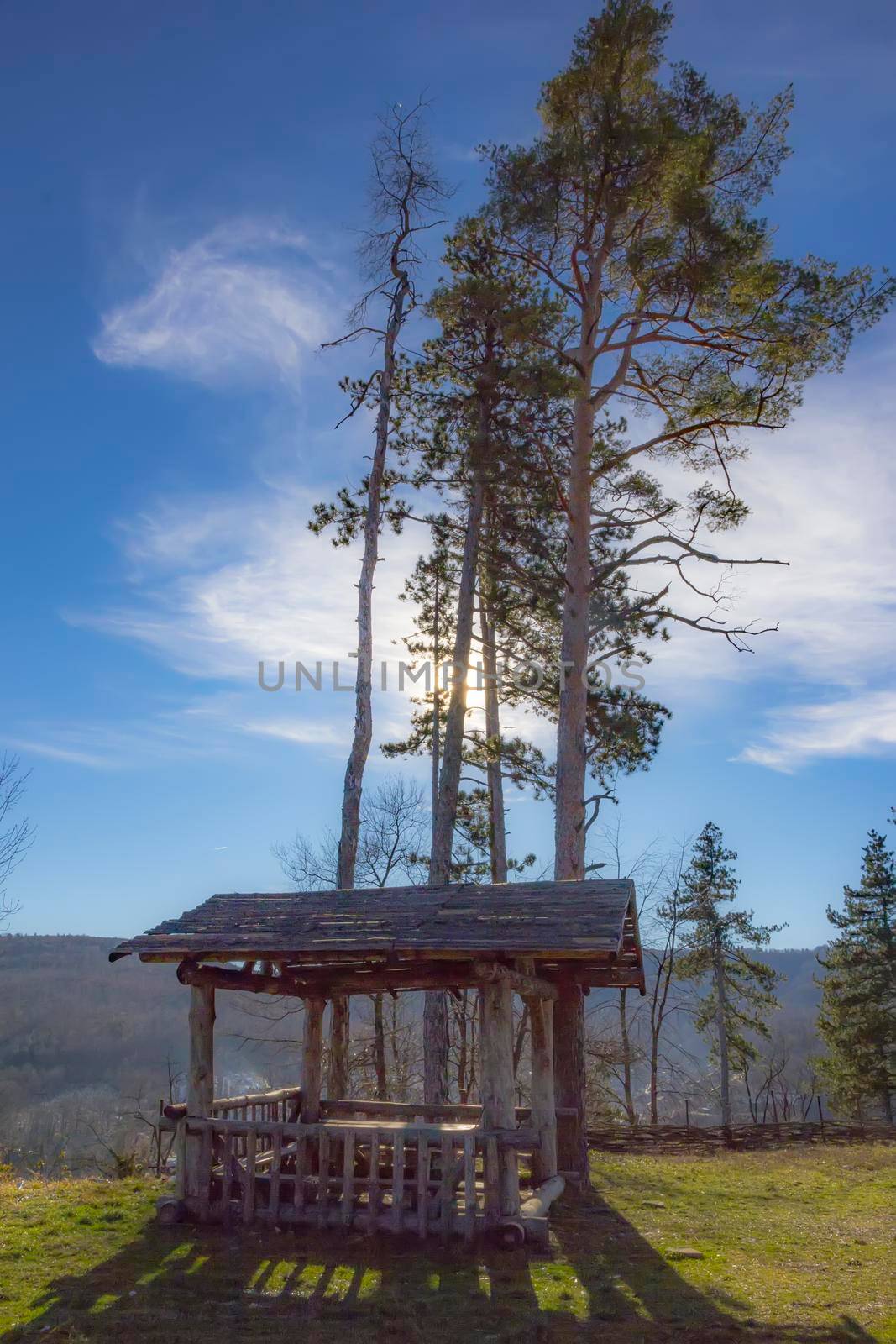 Wooden alcove with table and benches on a mountain. A place to rest in the heat in the mountains