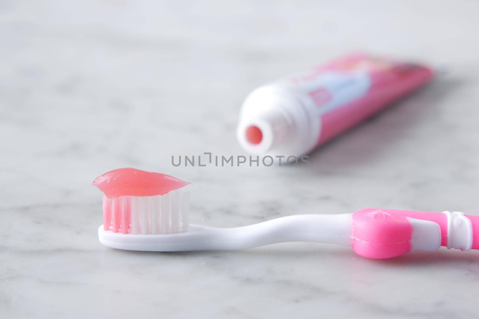 pink color child tooth brush with paste.