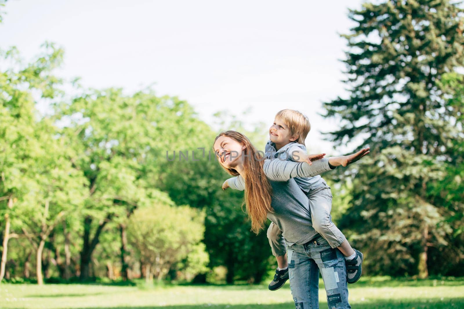 happy mother and son playing in the Park. the photo has a blank space for text