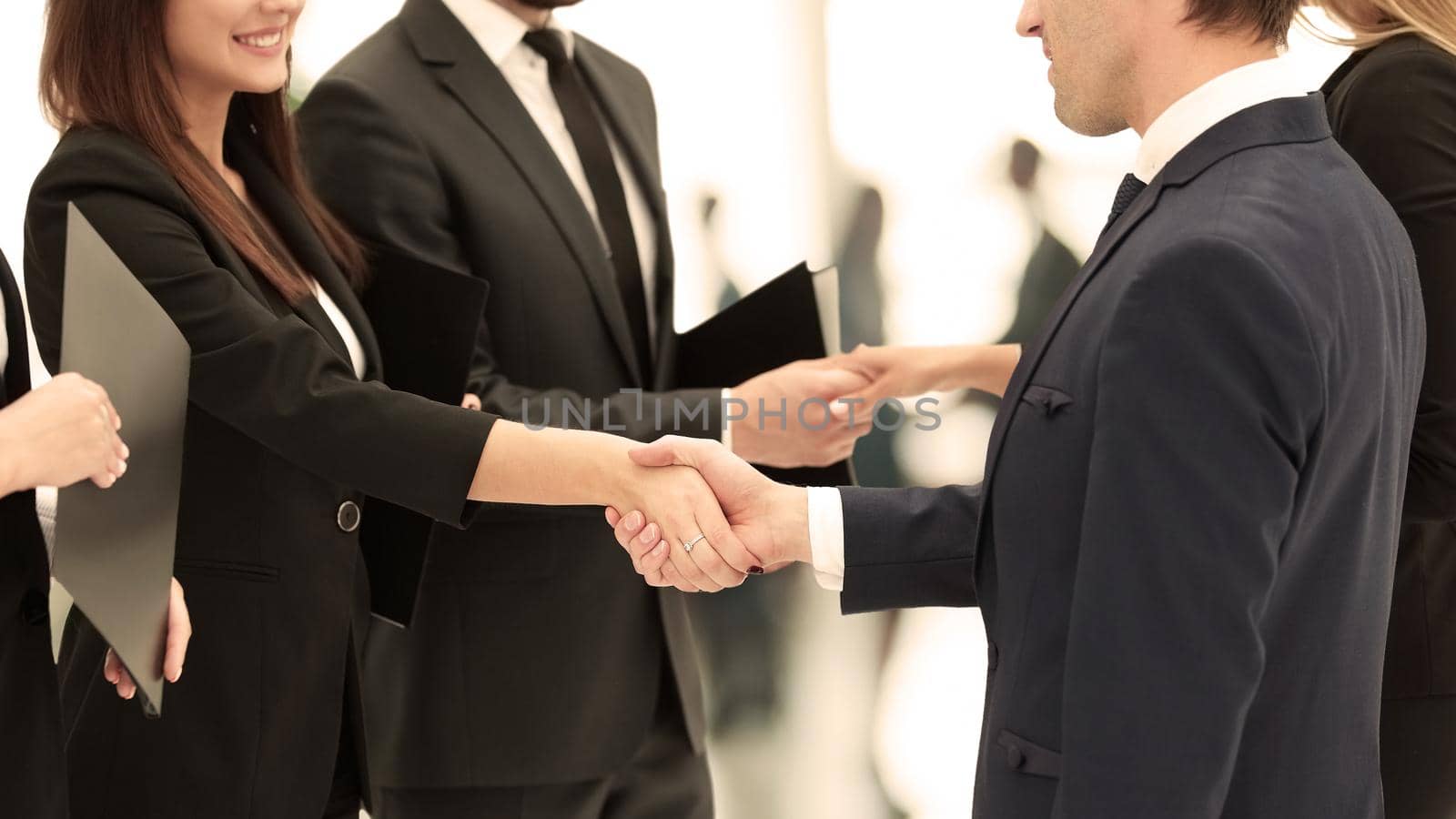 close-up of business partners shaking hands after signing of the contract against the background of the office