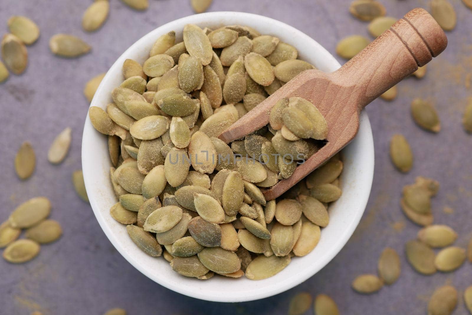 pumpkin seeds in a small bowl on black background ,