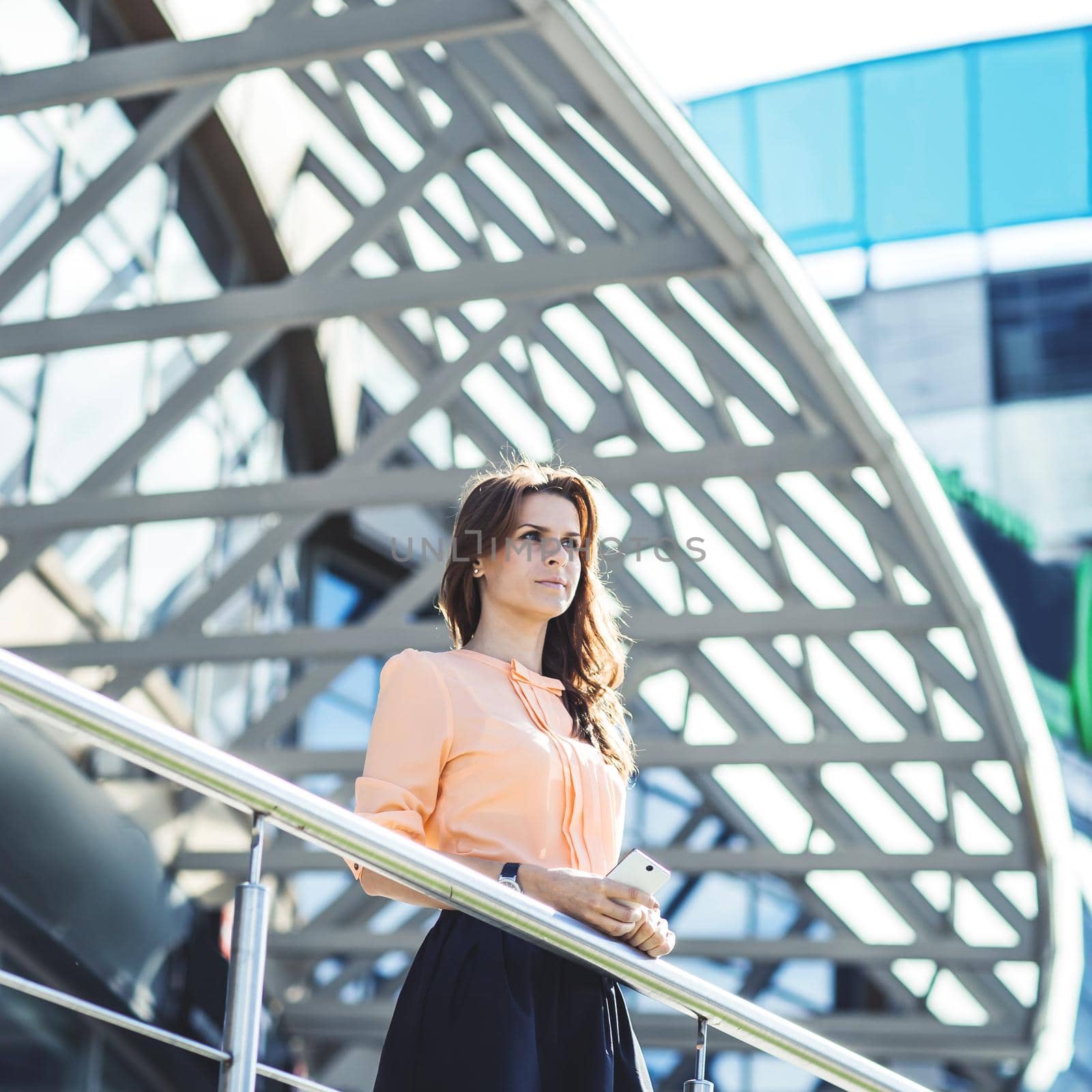 business woman standing on the balcony of the modern office and looks into the distance.the photo has a empty space for your text