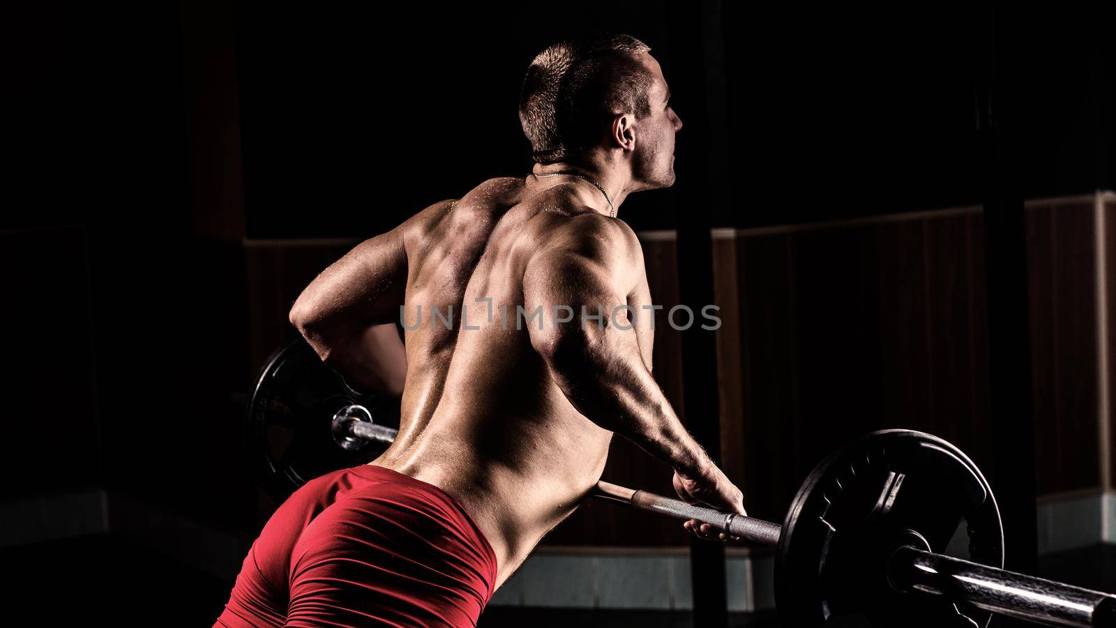 Beautiful Bodybuilder is engaged in a simulator in a modern gym