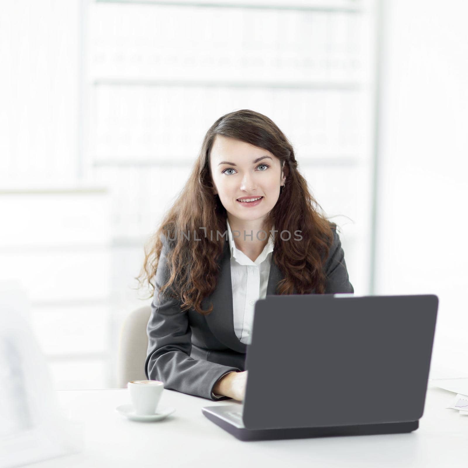 successful business woman sitting at the Desk in the office by SmartPhotoLab