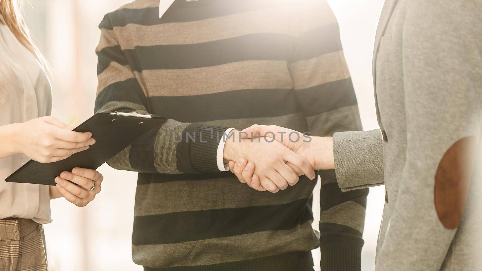 senior Manager shakes hands with the employee in a workplace in a modern office
