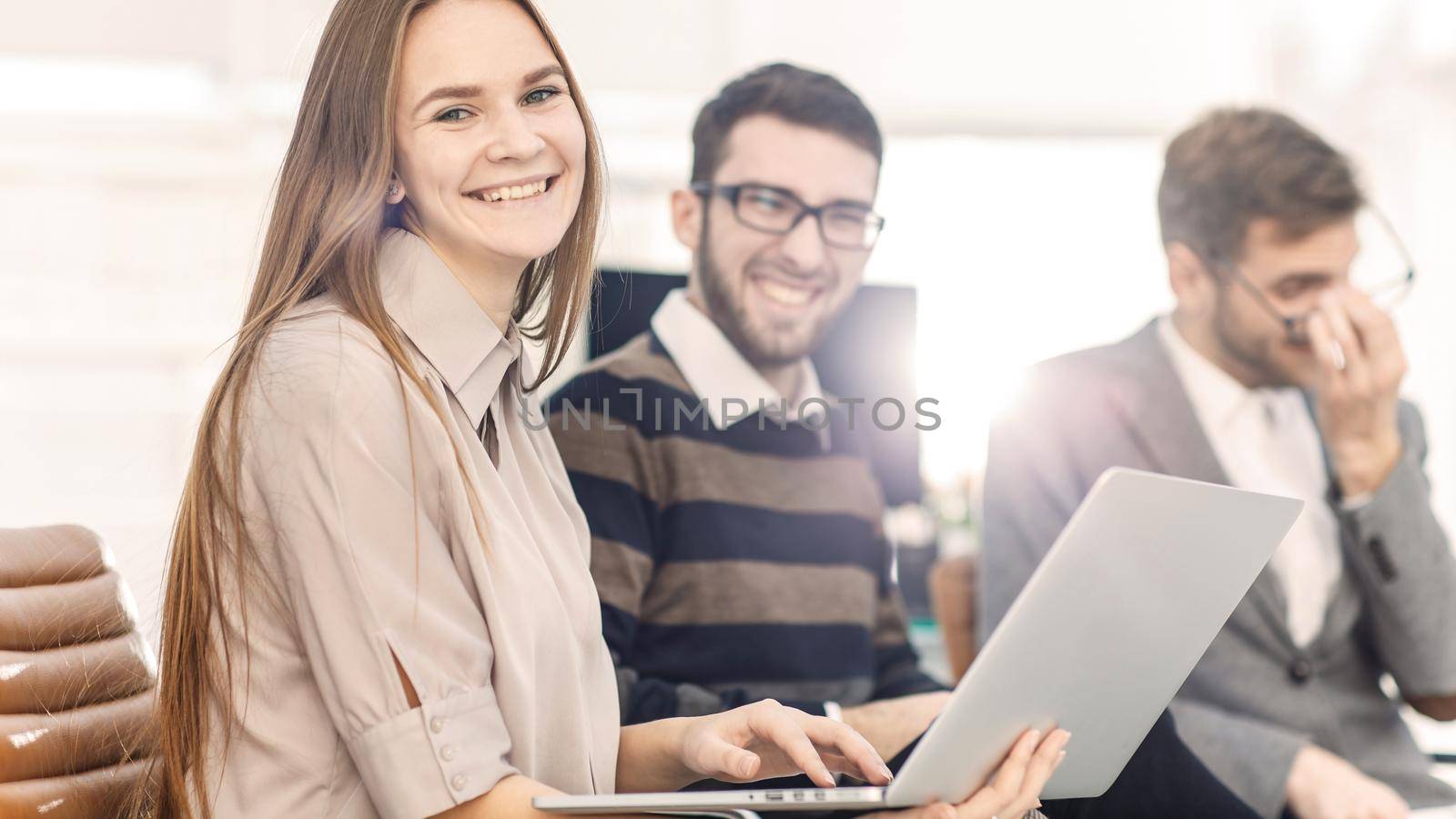 close-up of the company's employees with a laptop sitting in the lobby of the modern office.the photo has a empty space for your text.