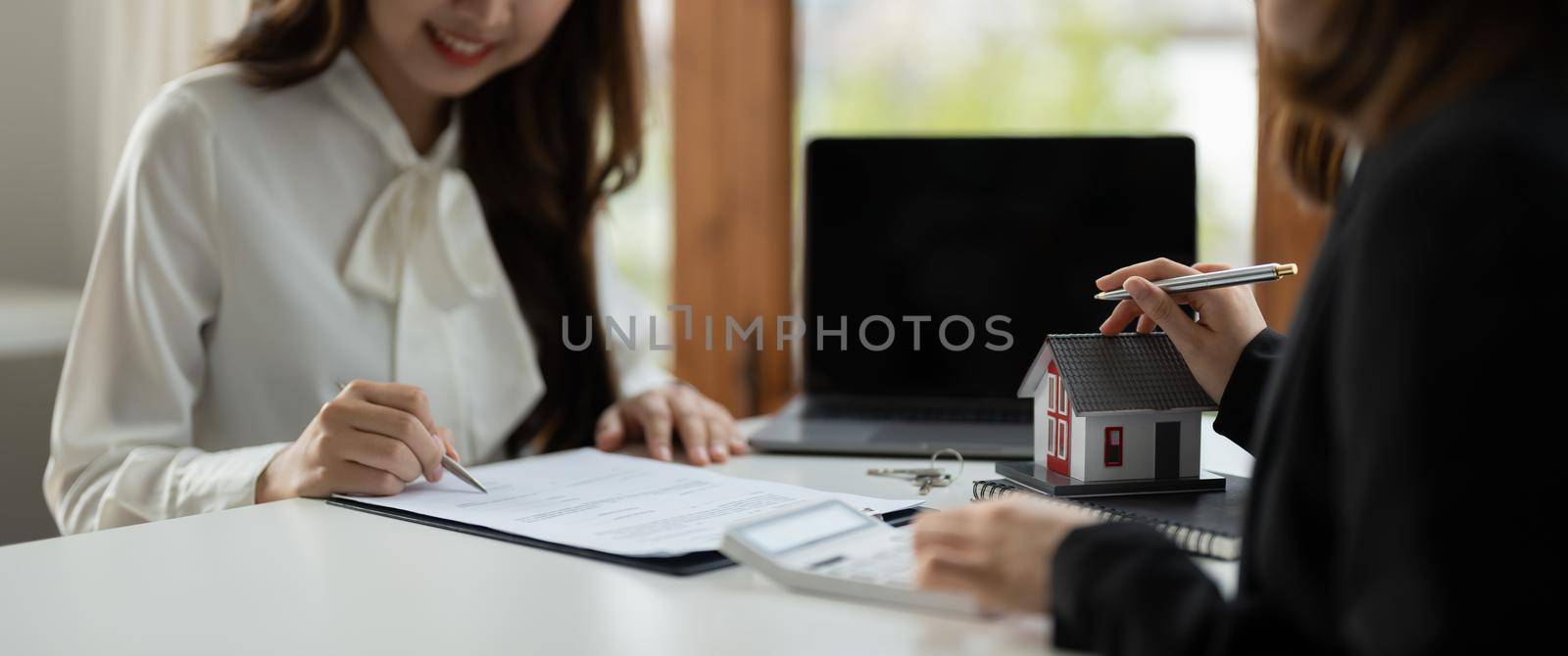 Real estate agent or bank officer describes the loan interest to the customer with home purchase contracts or on office loans and interest rates.
