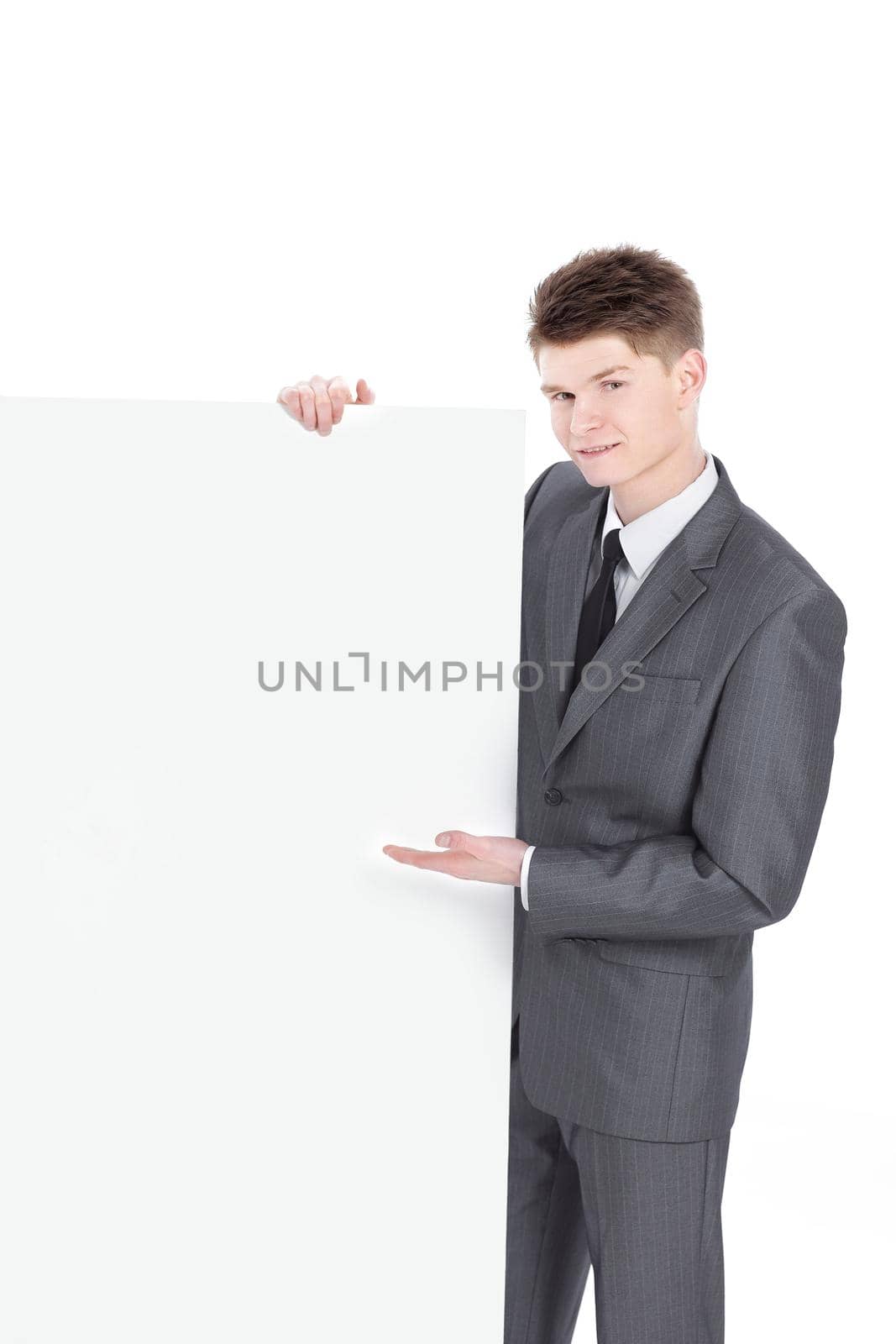 successful young businessman looking at blank banner .isolated on a white