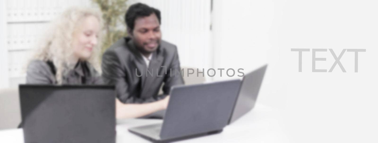younger employees discussing business issues in office in a blur by SmartPhotoLab