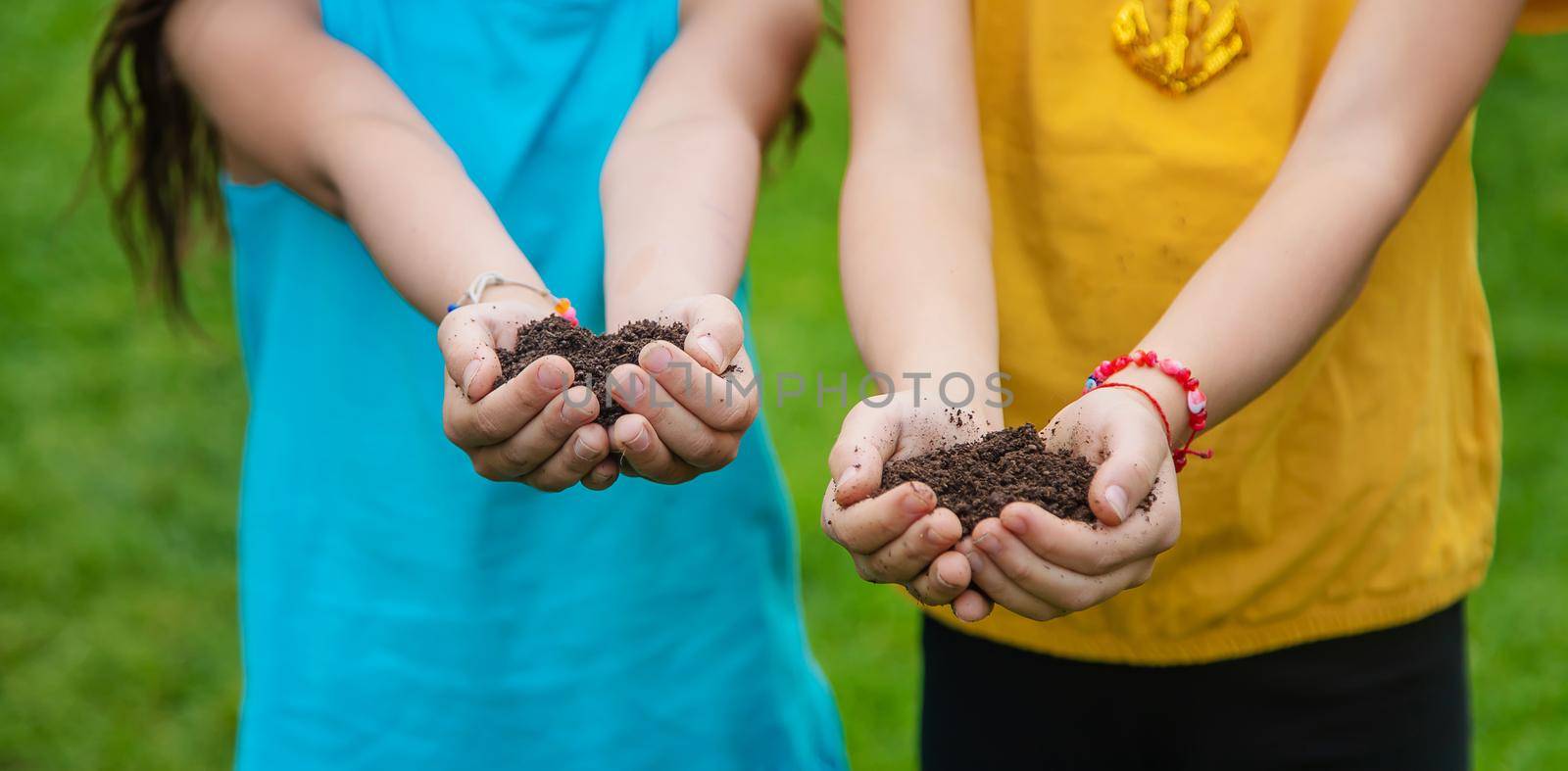 The child holds the soil in his hands. Selective focus. Kid.