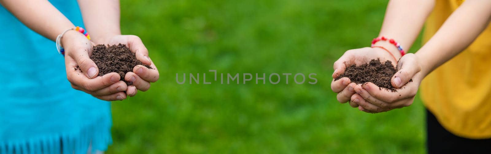 The child holds the soil in his hands. Selective focus. by yanadjana