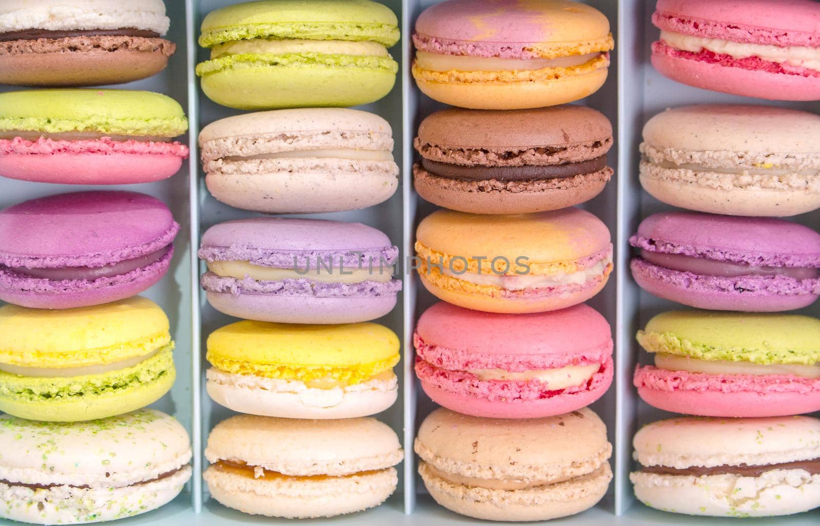 Set of different french cookies macaroons macaroons in a paper box. Top view. Closeup. Coffee, chocolate, vanilla, lemon, rapsberry, strawberry, pistachio, violet, rose, orange tastes macaroons