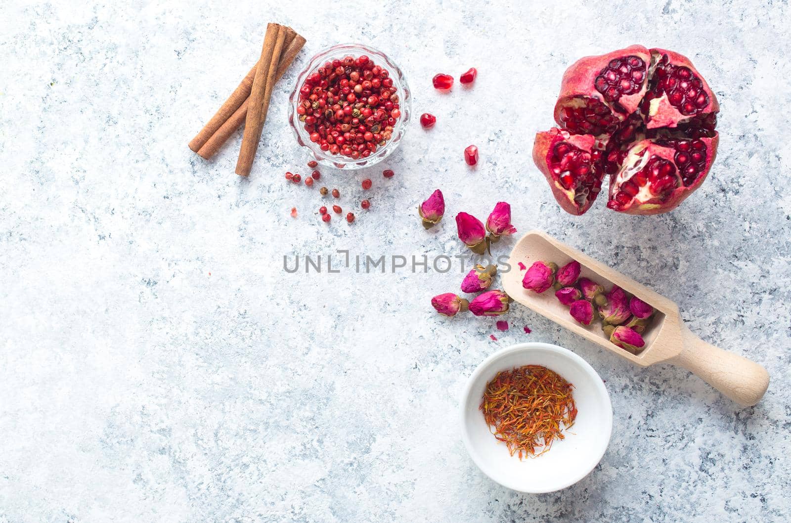 Arab ingredients, middle eastern food. Space for text. Arabic cuisine ingredients, white concrete background. Rose buds, spices, pomegranate, pepper. Halal food making. Top view. Arab food concept