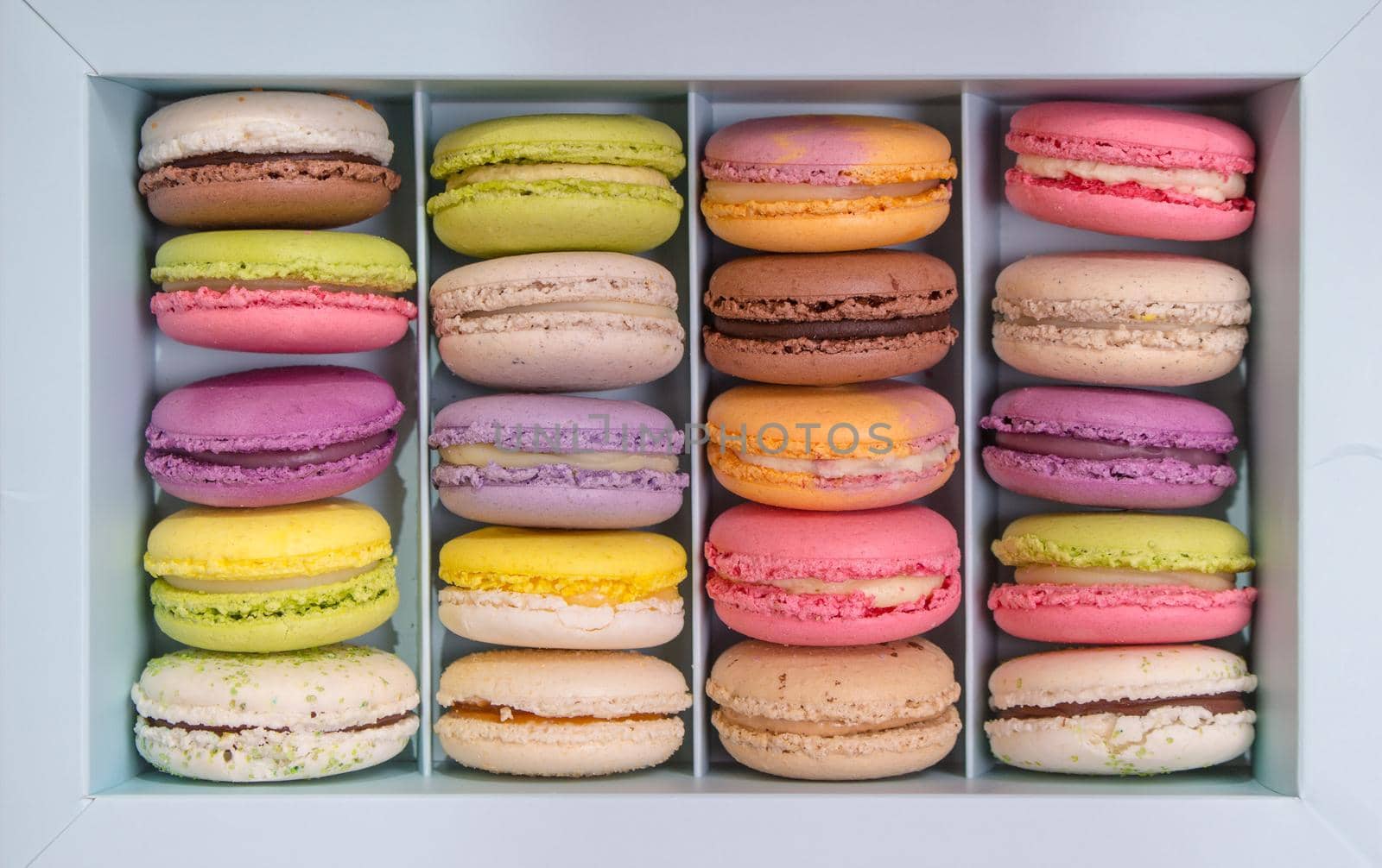Set of different french cookies macaroons macaroons in a paper box. Top view. Coffee, chocolate, vanilla, lemon, rapsberry, strawberry, pistachio, violet, rose, orange tastes macaroons